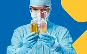 A person in personal protective equipment (PPE) is holding two test tubes, one containing a yellow liquid and the other containing a pink liquid. The background is a vibrant blue with a yellow abstract shape, creating a striking contrast with the figure and the test tubes.