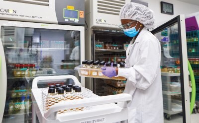 Scientist placing bottles into an incubator in a laboratory setting