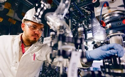 Manufacturing facility worker adjusting equipment, representing MilliporeSigma's manufacturing workflow product offerings for medical device manufacturing.