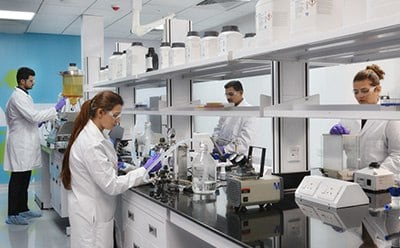 Laboratory  workers at the bench performing experiments to represent Merck's Research and Development