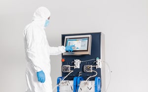 Scientist in bunny suit using Bio4C ACE™ software on the Mobius® Cell Retention System.