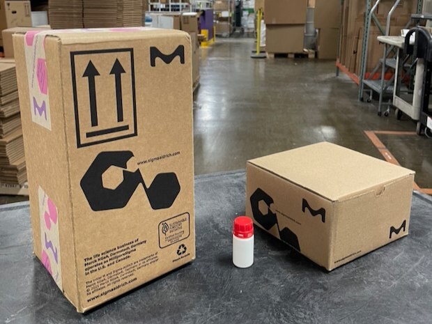 Two boxes are seen in the image. The one on the left is significantly smaller than the box on the right. In the middle a bottle shows that packaging it into the box on the right is much more size appropriate than the left box. 