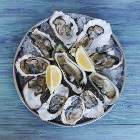 High angle view of raw oysters and lemon slices on a plate on a table